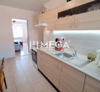 Kitchen in a 2-room apartment with a dining table, cabinets, and a kitchen counter.