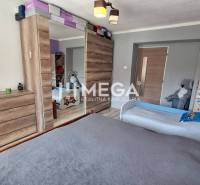 A bedroom in a two-room apartment with wooden furniture, wardrobes with sliding doors, and toys.