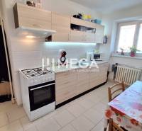 A kitchen in a 2-room apartment with a stove and a dining table, bright and cozy atmosphere.