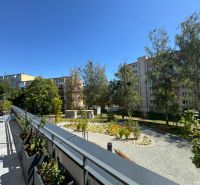 View of greenery and apartment buildings from the balcony on Popradská Street in Košice.