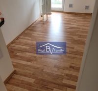A room with a wooden floor and a radiator in a 3-room apartment.