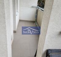 A balcony in a 3-room apartment with tiles and a railing.