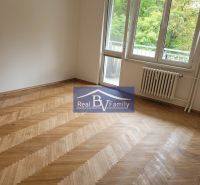 A room in a 3-room apartment, wooden parquet floors, large window, view of nature.