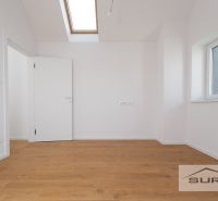 A room in a family house with a wooden decor floor and a skylight.