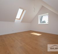 A room with windows and a wooden decor floor in a family house.