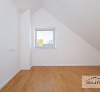 Attic room with a window and a wooden decor floor in a family house.