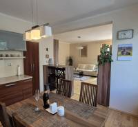 Interior of a family house with a kitchen, dining table, and floor with wood decor.