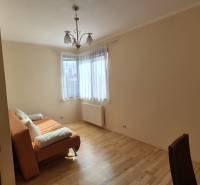 Living room in a family house with an orange sofa and a wooden decor floor.