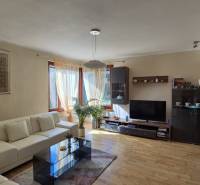 Living room in a family house with a sofa, TV, painting, and floor with wooden decor.