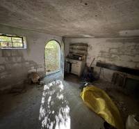 A spacious room with open doors, concrete walls, and diffused natural light in the Cabin.