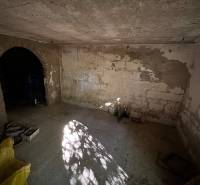 An empty room with a raw concrete floor and ceiling in a cabin in Veľké Turovce.