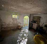 Abandoned room in a cabin with open doors and old furniture.
