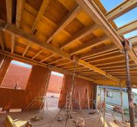 Construction of houses in Ľubotice with wooden beams and brick walls.