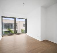 A bright room with a large window and a wooden decor floor in a 4-room apartment.