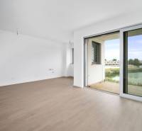 Interior of a 4-room apartment with a wooden decor floor and large glass doors to the terrace.