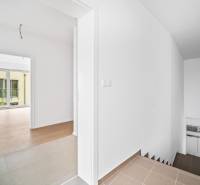 Interior of a 4-room apartment with a staircase and flooring with a wooden decor.