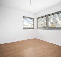 A room with a wooden decor floor and large windows in a 4-room apartment.