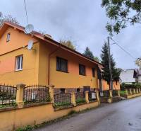 A family house on Škoruby in Kolárovice with a colorful facade and a small yard.