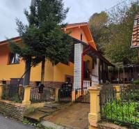 A family house on Škoruby in Kolárovice with a garden and a tree in the front yard.