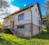 A family house in Papradno, a two-story building with large windows and stairs, surrounded by greenery.