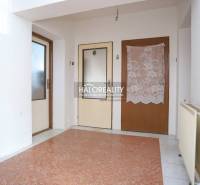 Entrance hall of a family house with tiles and two wooden doors.