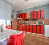 A kitchen with red cabinets and a dining table in a family house.