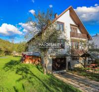 A family house in Papradno with a large garden, trees, and a wooden tool shed.