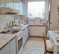 A kitchen in a 3-room apartment with an extended dining table and light accessories.