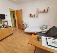 Living room in a three-room apartment with a wooden decor floor and furniture.