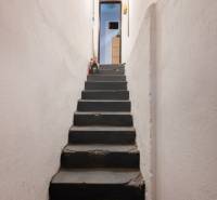 A narrow staircase leading to a hallway with a closet in a 3-room apartment.