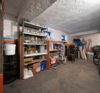 A storage space with jars and a bicycle in the basement of a 3-room apartment.