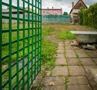 Garden on Matice Slovenská Street in Veľký Šariš with a fence and a paved walkway.