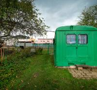 A garden with a fence and a green shelter on Matice Slovenskej Street in Veľký Šariš.