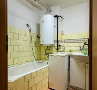 A bathroom in a 3-room apartment with a bathtub, washing machine, and gas boiler.