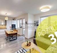 A kitchen in a three-room apartment with a wooden decor floor and a dining table.