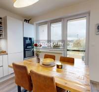 A kitchen in a 3-room apartment with a wood-patterned floor and large windows.