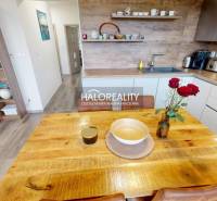 A kitchen in a 3-room apartment with wooden decor on the floor, a wooden table, decorations.