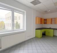 Offices with tiled floors, white walls, a large window, and a colorful kitchen unit.