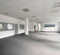 Spacious offices with carpet, white walls, and large windows.