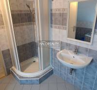 A bathroom with a built-in bathtub, tiles, and a skylight in a 2-room apartment.