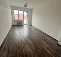 A room in a 3-room apartment with a wood-decor floor and large windows.