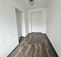 Narrow room with wood-patterned flooring, pendant light, 3-room apartment.