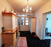 A hallway in a 3-room apartment with light furniture, carpeted floor, and a chandelier.