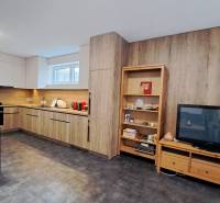 Kitchen corner in a 2-room apartment with a wooden decor floor and dark furniture.