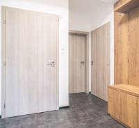Interior of a 2-room apartment with a wooden decor floor and light-colored doors.