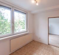 A room with a large window, tiles, and a wooden decor floor in a 3-room apartment.