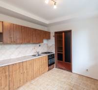 A kitchen in a 3-room apartment with wooden cabinets and tiles, floor with a pattern.