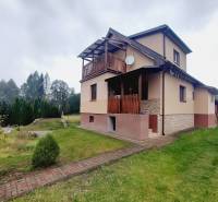 A family house in Liptovská Porúbka with a terrace, lawn, and trees on the property.