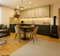 A kitchen with a corner unit, a dining table, and a stove in a family house.