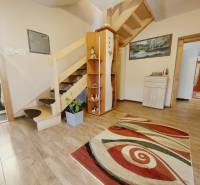 Wooden staircase, carpet, wood-patterned floor, and decor in a family house.